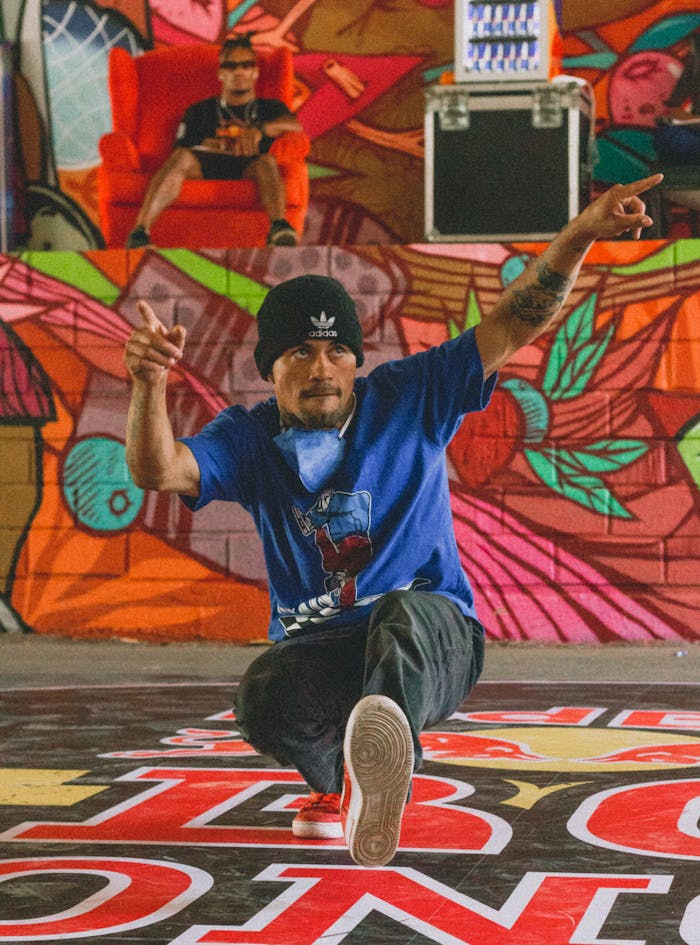 Energetic street dancer in action against vibrant graffiti, showcasing hip-hop culture.